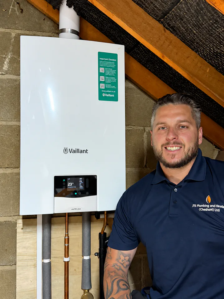 Jordan from JTS next to a new Vaillant boiler in a loft